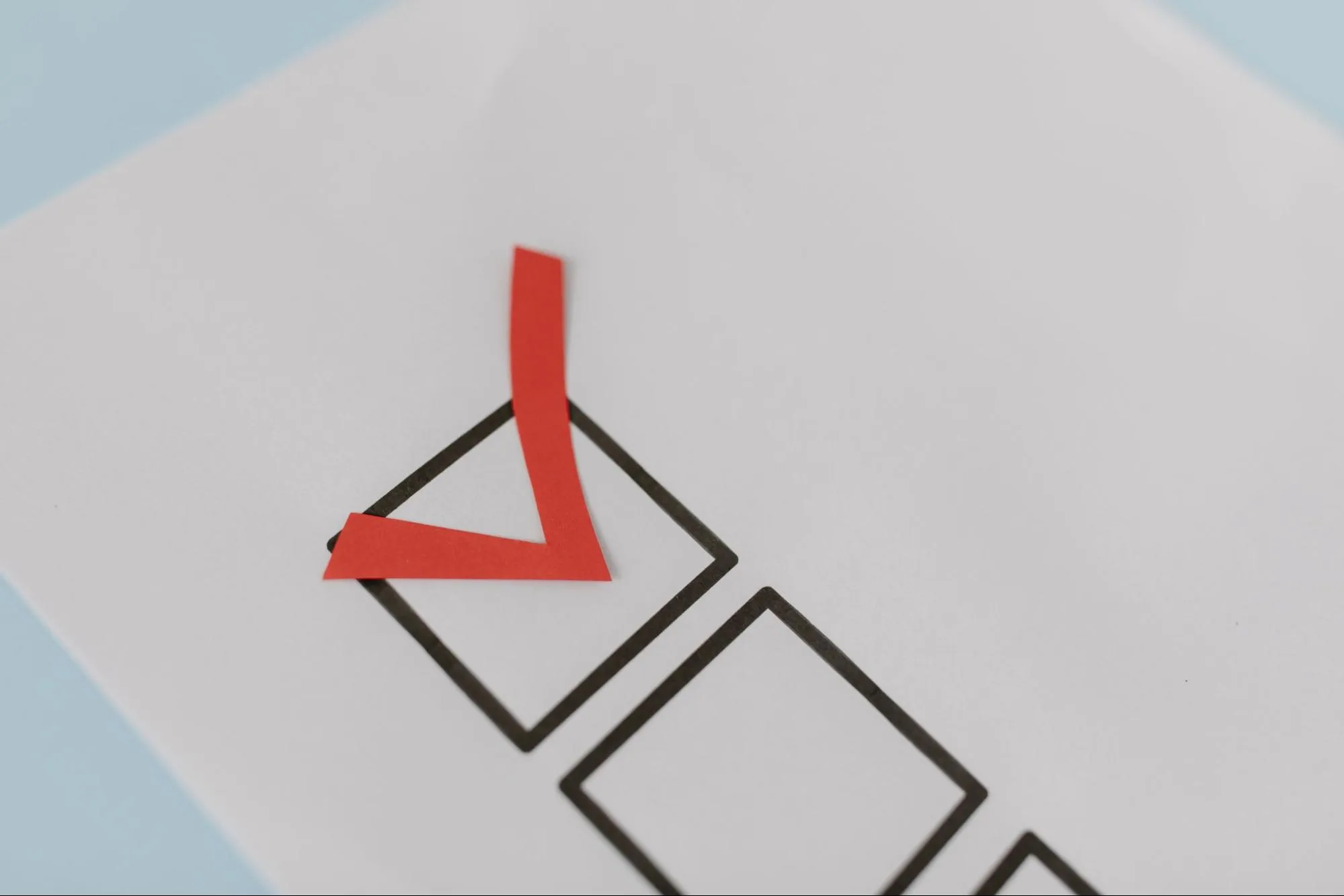 A red tick placed in the first of a row of empty checkboxes printed on a sheet of paper, representing a pre-shipment compliance check