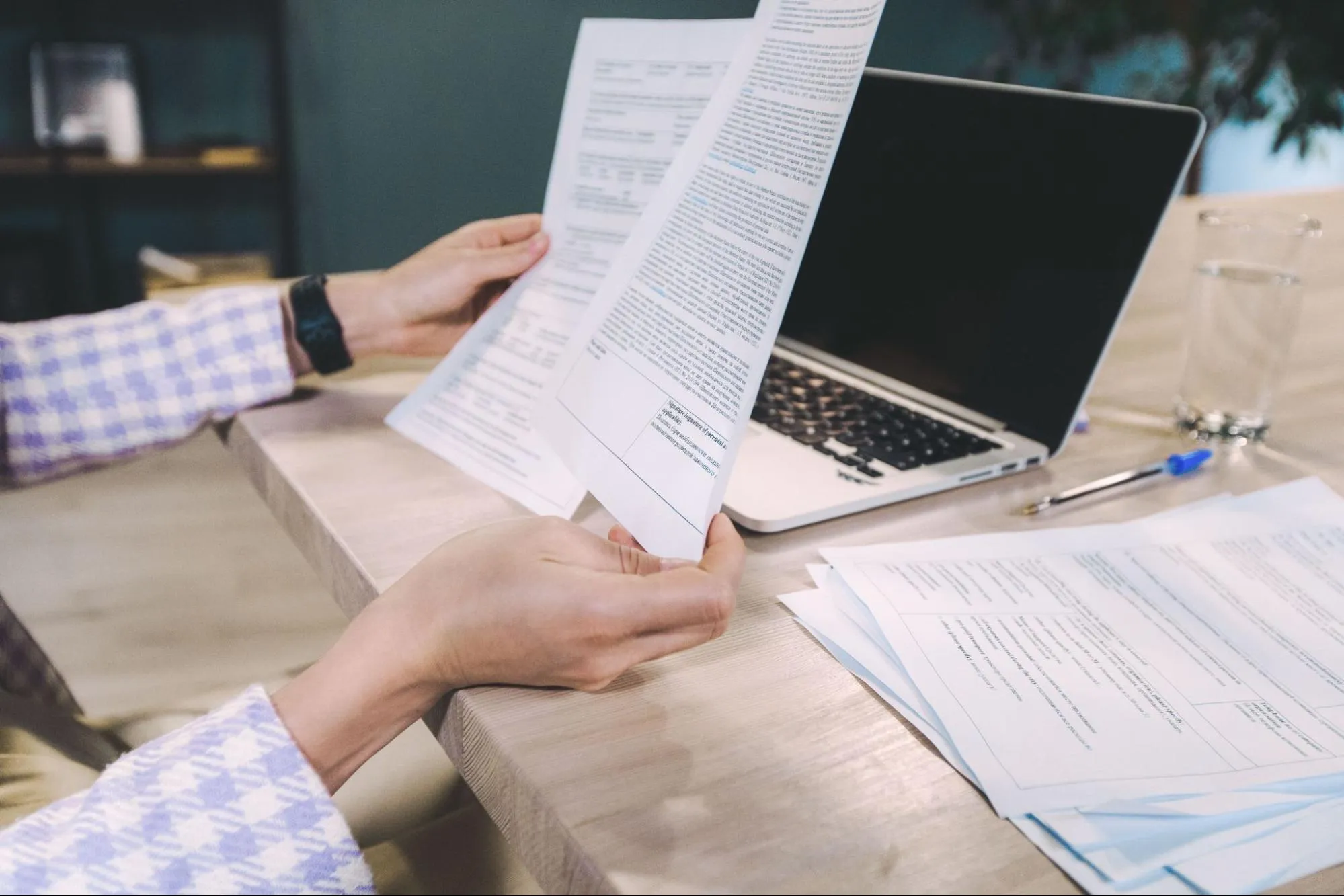 A person reviewing printed documents beside a laptop, representing a compliance review before entering the EU market